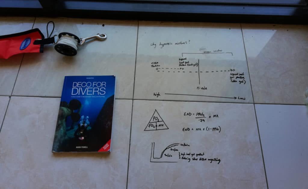 scuba diving sitting on a table with some mathematical formula next to it.