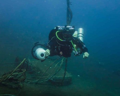 Diver hovers next to a line performing a decompression stop after doing some DPV diving