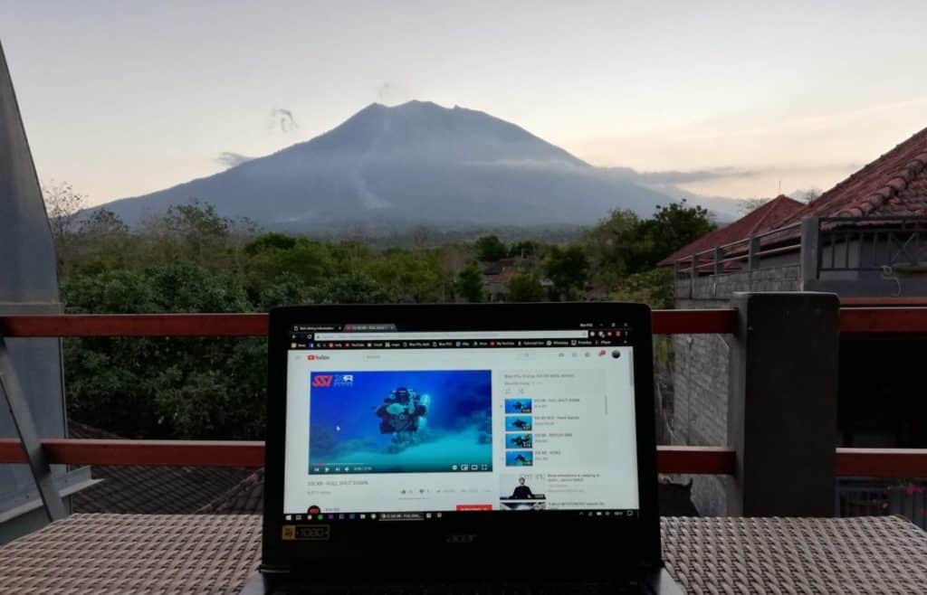 Viewing SSI XR skills on youtube on a laptop. Mount Agung in Bali is in the background at sunset.