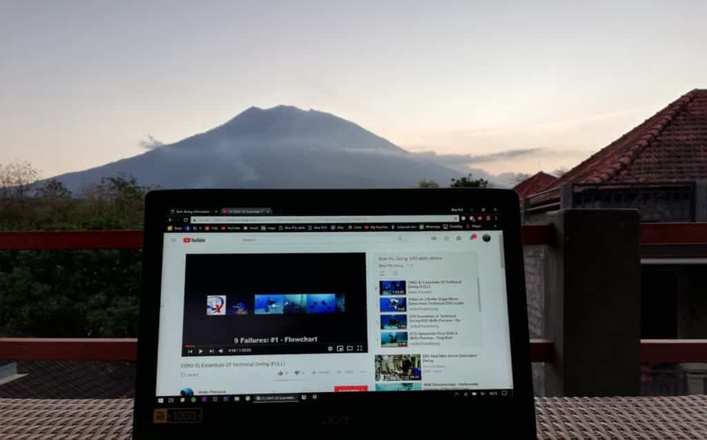 Watching UTD skills on a laptop, as Bali's Mount Agung sits in the background just prior to sunset