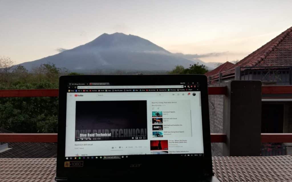 Watching Raid skills on youtube. Mount Agung sits in the background
